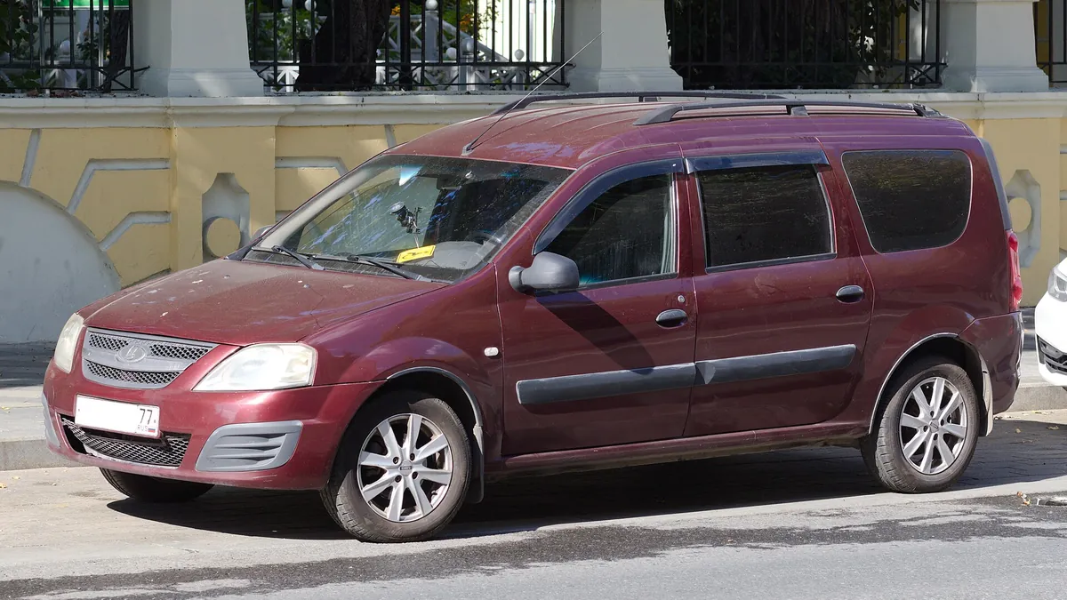 Красный автомобиль-универсал, припаркованный у тротуара