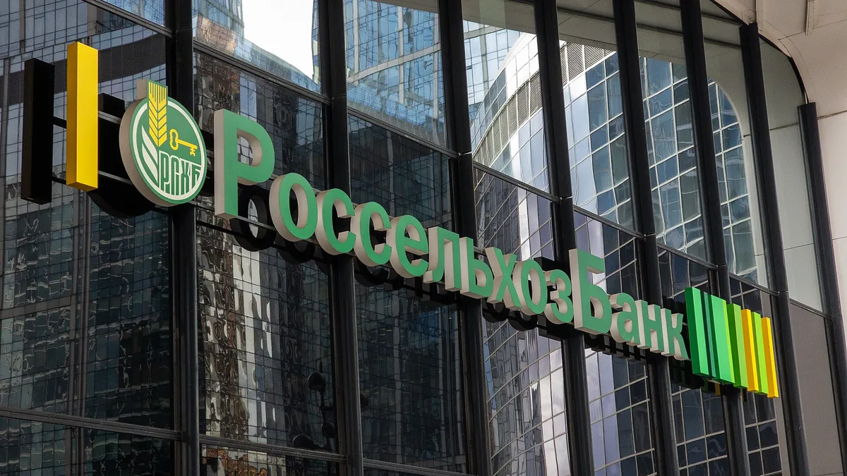 Зелёная вывеска Россельхозбанка на стеклянном фасаде здания в Москве