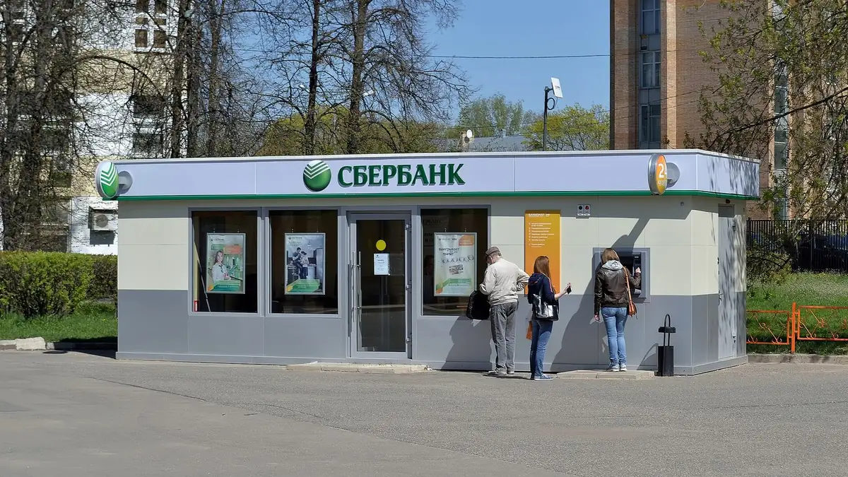 Отделение Сбербанка в отдельном павильоне, у банкомата стоят люди
