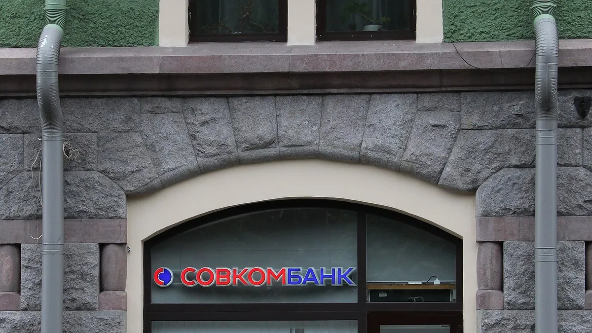 Вход в отделение Совкомбанка в старинном здании с витринами